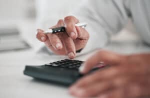 Closeup of hands on a calculator evaluating LTD lump-sum settlement offers.