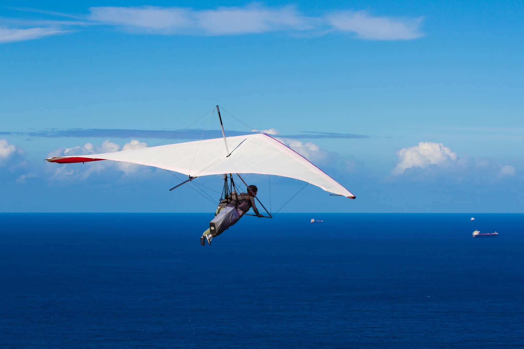 Man hang-gliding over a calm ocean on a sunny day; lifestyle choices’ effect on LTD eligibility.